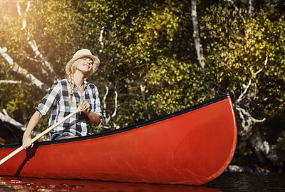 Buy stock photo Shot of an attractive young woman spending a day kayaking on the lake