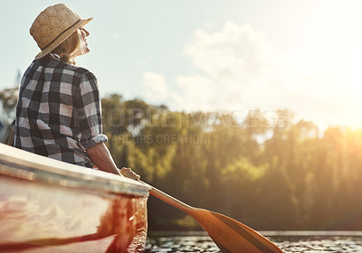 Buy stock photo Shot of an attractive young woman spending a day kayaking on the lake