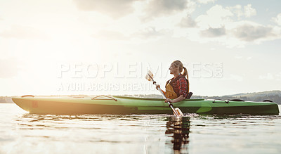 Buy stock photo Shot of a young woman kayaking on a lake