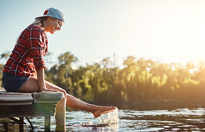 Buy stock photo Shot of a happy young woman spending time by the lakeside