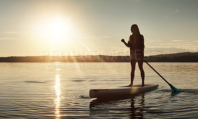 Buy stock photo Lake, sunset and woman on paddle board for relax, water sports and vacation on river for tourism. Sunlight, summer and holiday in Germany for adventure and balance practice, swimsuit and travel