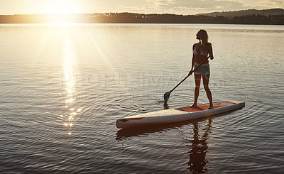 Buy stock photo Lake, sunset and woman on paddle board for relax, water sports and vacation on river for tourism. Sunlight, summer and holiday in Germany for female person, view and travel fitness for adventure