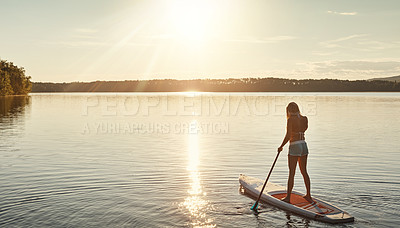 Buy stock photo Lake, sunset and woman on paddle board for relax, water sports and vacation on river for tourism. Sunshine, summer and holiday in Germany for female person, swimsuit and back fitness for adventure