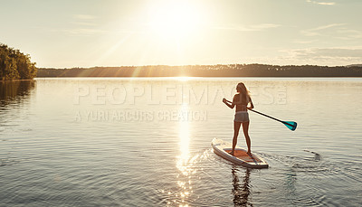 Buy stock photo Lake, sunset and woman on paddle board for relax, water sports and vacation on river for tourism. Sunshine, summer and holiday in Germany for female person, swimsuit and travel fitness for adventure