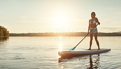 Buy stock photo River, sunset and woman on paddle board with sunshine, water sport and vacation on lake for tourism. Exercise, summer or holiday in Germany for female person, swimsuit or travel fitness for adventure