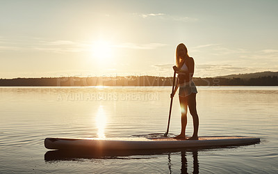 Buy stock photo Lake, sunset and woman on paddle board for balance, water sport and vacation on river for tourism. Nature, summer or holiday in Germany for female person, swimsuit or travel exercise for adventure