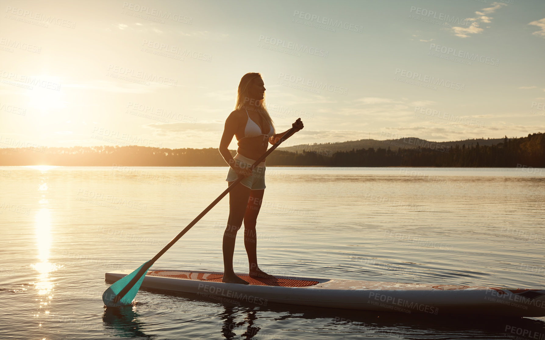 Buy stock photo River, sunset and woman on paddle board with sunshine, water sport and vacation on lake for tourism. Exercise, summer or holiday in Germany for female person, swimsuit or travel fitness for adventure