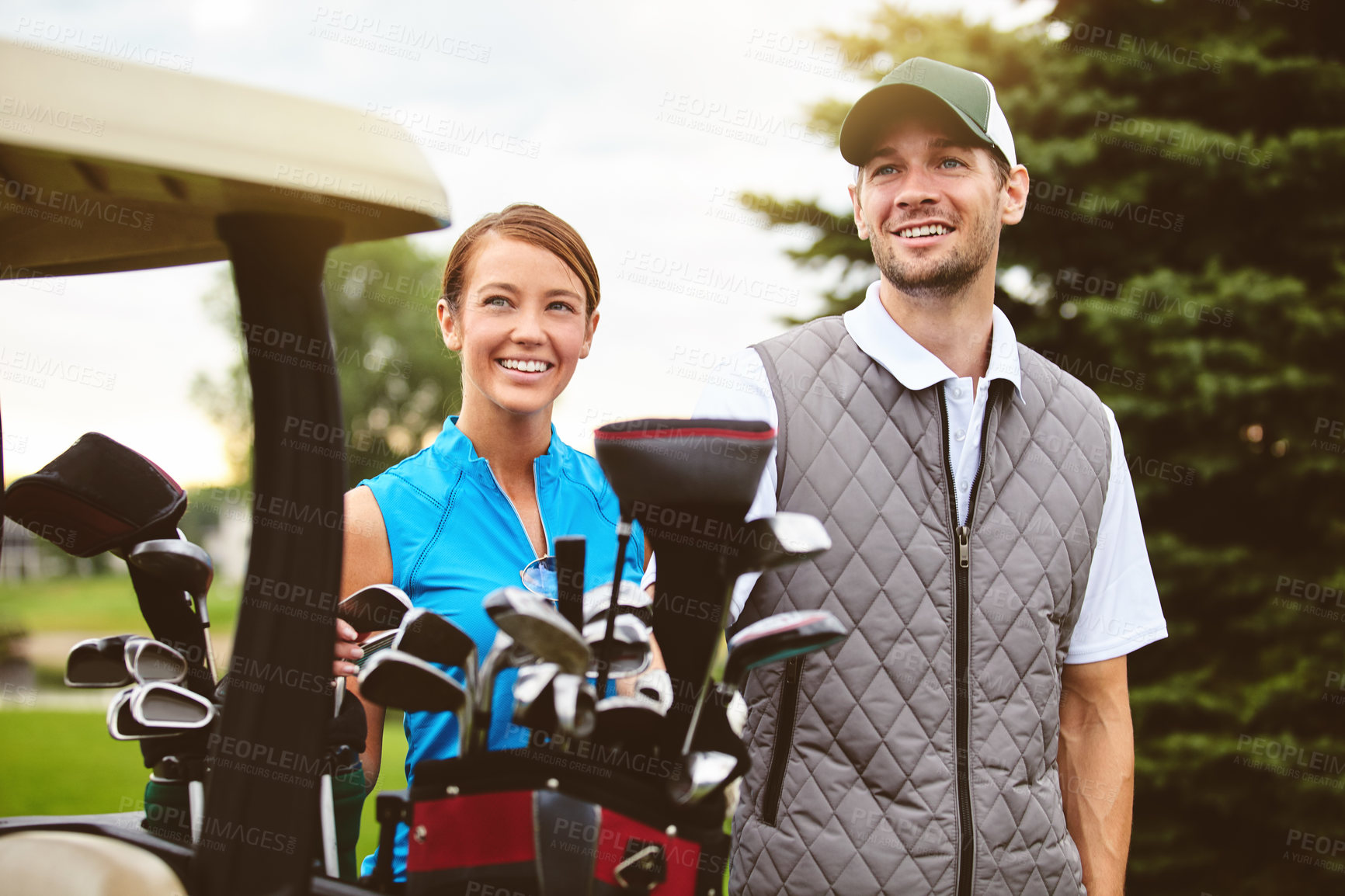 Buy stock photo Shot of an affectionate young couple spending a day on the golf course