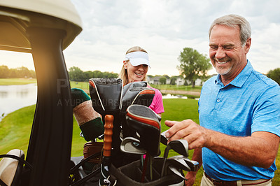 Buy stock photo Shot of an affectionate mature couple spending a day on the golf course