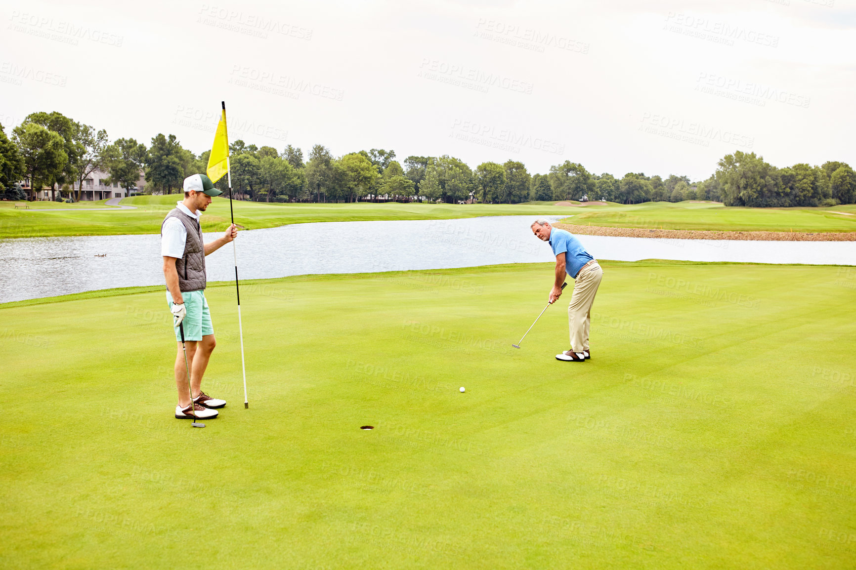 Buy stock photo Men, golf and outdoor on green for tee off in morning as members in club for health, wellness or business. Male people, putter and hole for sports, exercise or meeting as partner in company for deal