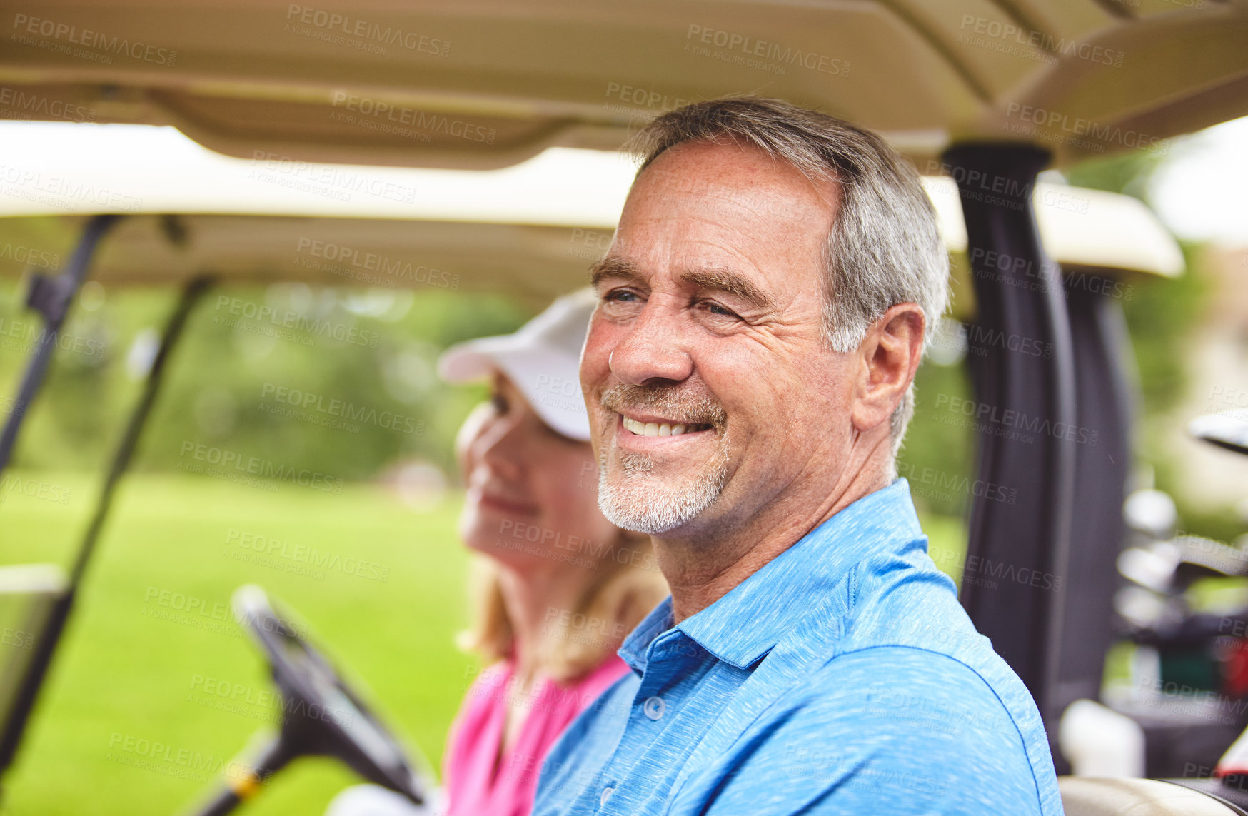 Buy stock photo Shot of a couple riding in a golf cart on a golf course