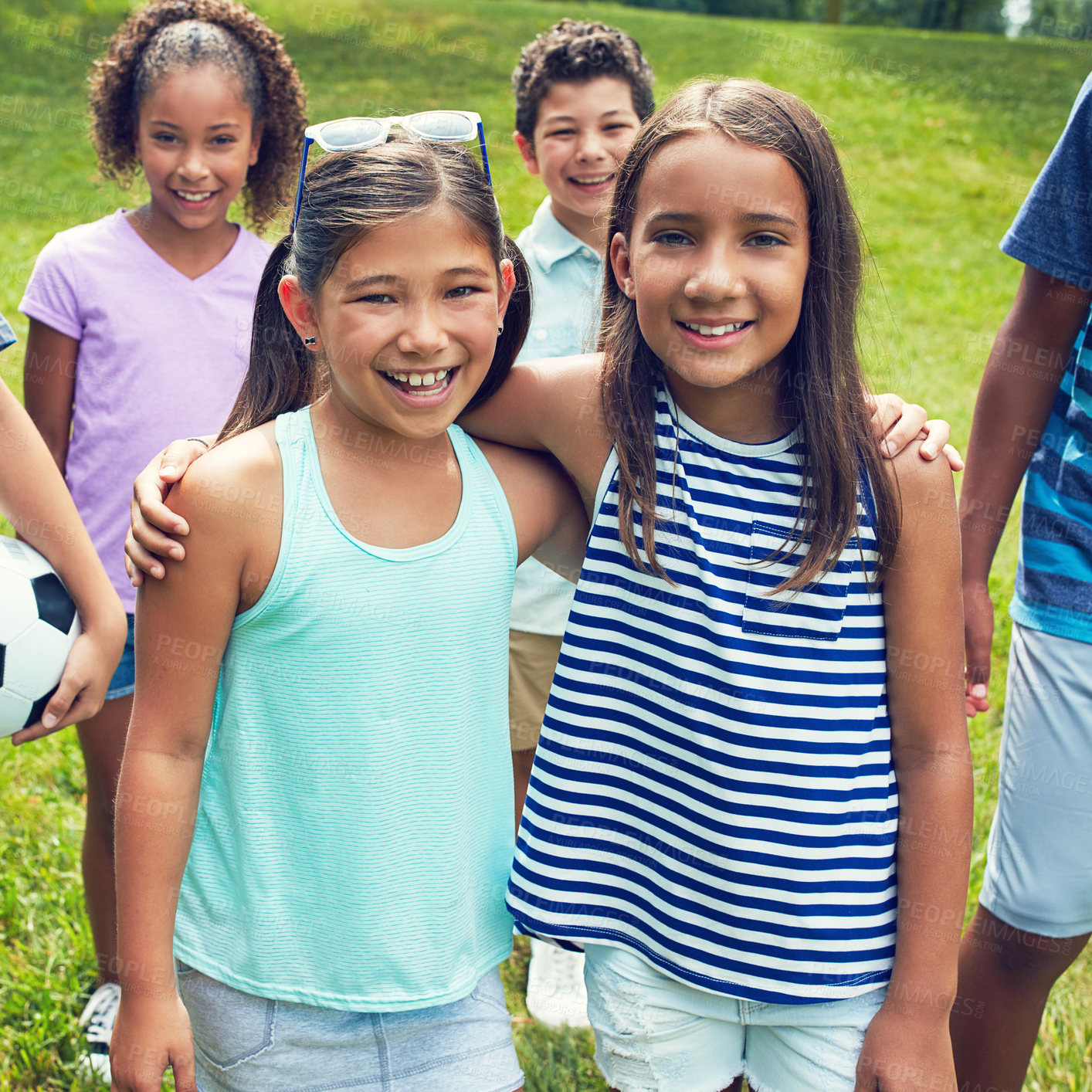 Buy stock photo Shot of two young girls hanging out with their friends in the park