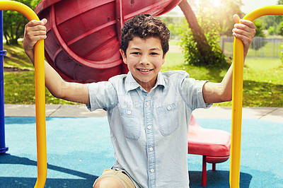 Buy stock photo Shot of a young boy playing on the jungle gym in the park