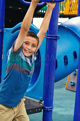 Buy stock photo Shot of a young boy playing on the jungle gym in the park