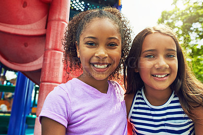 Buy stock photo Shot of two young friends hanging out together at a playground