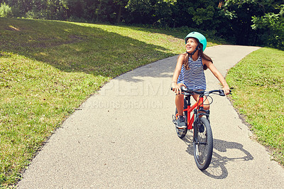 Buy stock photo Shot of a young girl out for a bicycle ride in the park