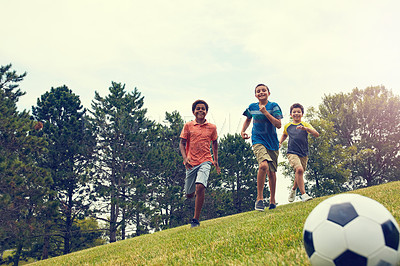 Buy stock photo Shot of young boys playing soccer on a field outdoors
