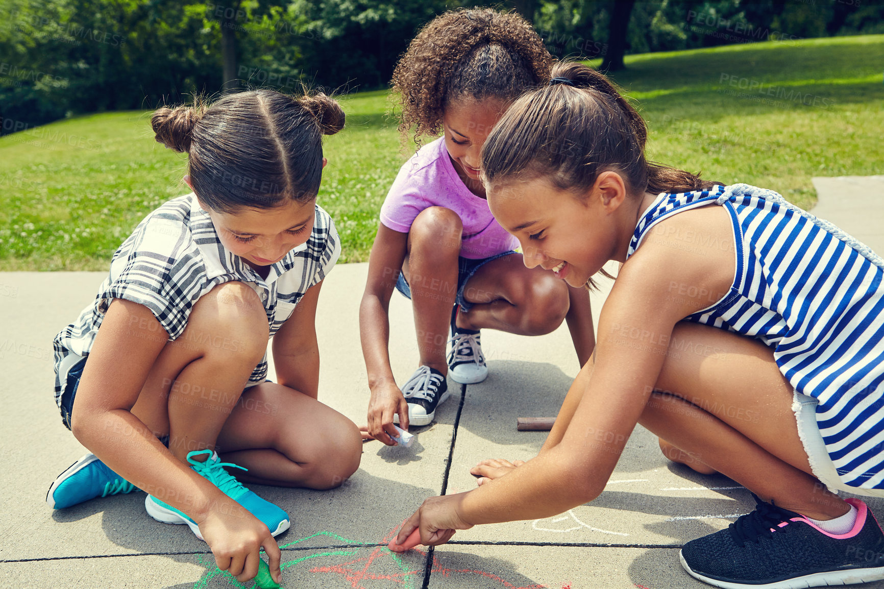 Buy stock photo Girl, group and drawing on ground with chalk at school for learning, diversity and creativity. Children, art and happy in sunshine on sidewalk, path and writing for shape, lines or pattern at academy