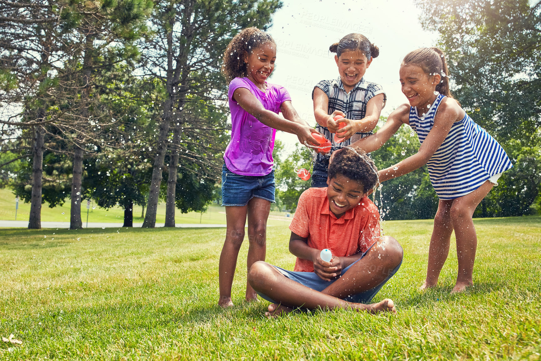 Buy stock photo Shot of adorable children playing with water balloons outdoors