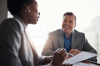 Buy stock photo Shot of two businesspeople going through paperwork in an office