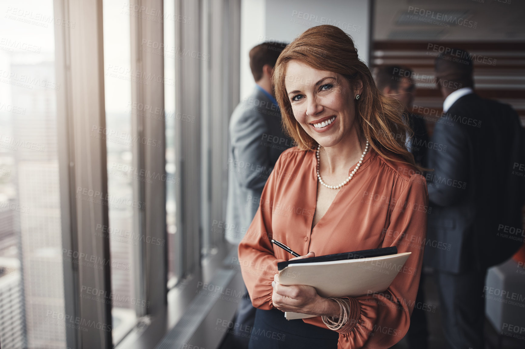 Buy stock photo Portrait of a professional businesswoman standing in an office with colleagues in the background
