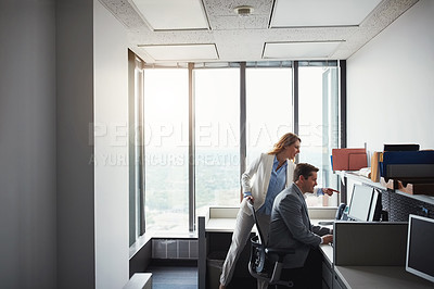 Buy stock photo Cropped shot of woman standing behind a man as he work on his computer