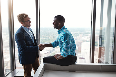 Buy stock photo Shot of two businesspeople shaking hands in an office