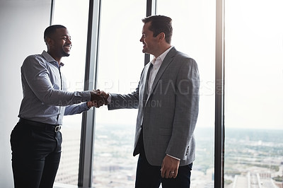Buy stock photo Cropped shot of two corporate businessmen shaking hands during a meeting in the boardroom