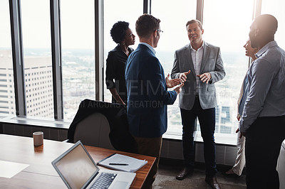 Buy stock photo High angle shot of a group of corporate businesspeople meeting in their boardroom