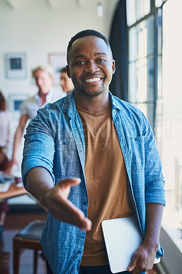 Buy stock photo Shot of a young man extending his arm for a handshake in a modern office