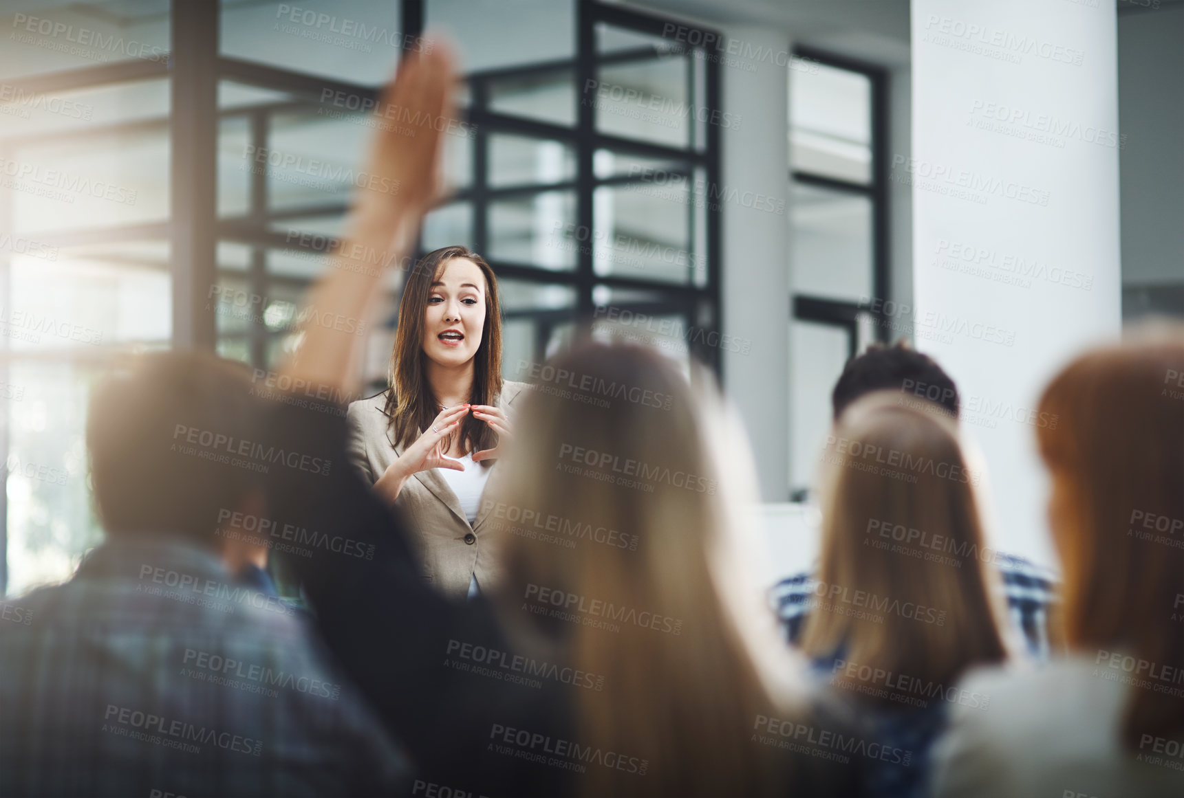 Buy stock photo Woman speaker at seminar, audience with hands up for questions and answers at training presentation or meeting. Feedback, opinion and ideas, group of people at conference, hand in air and question.