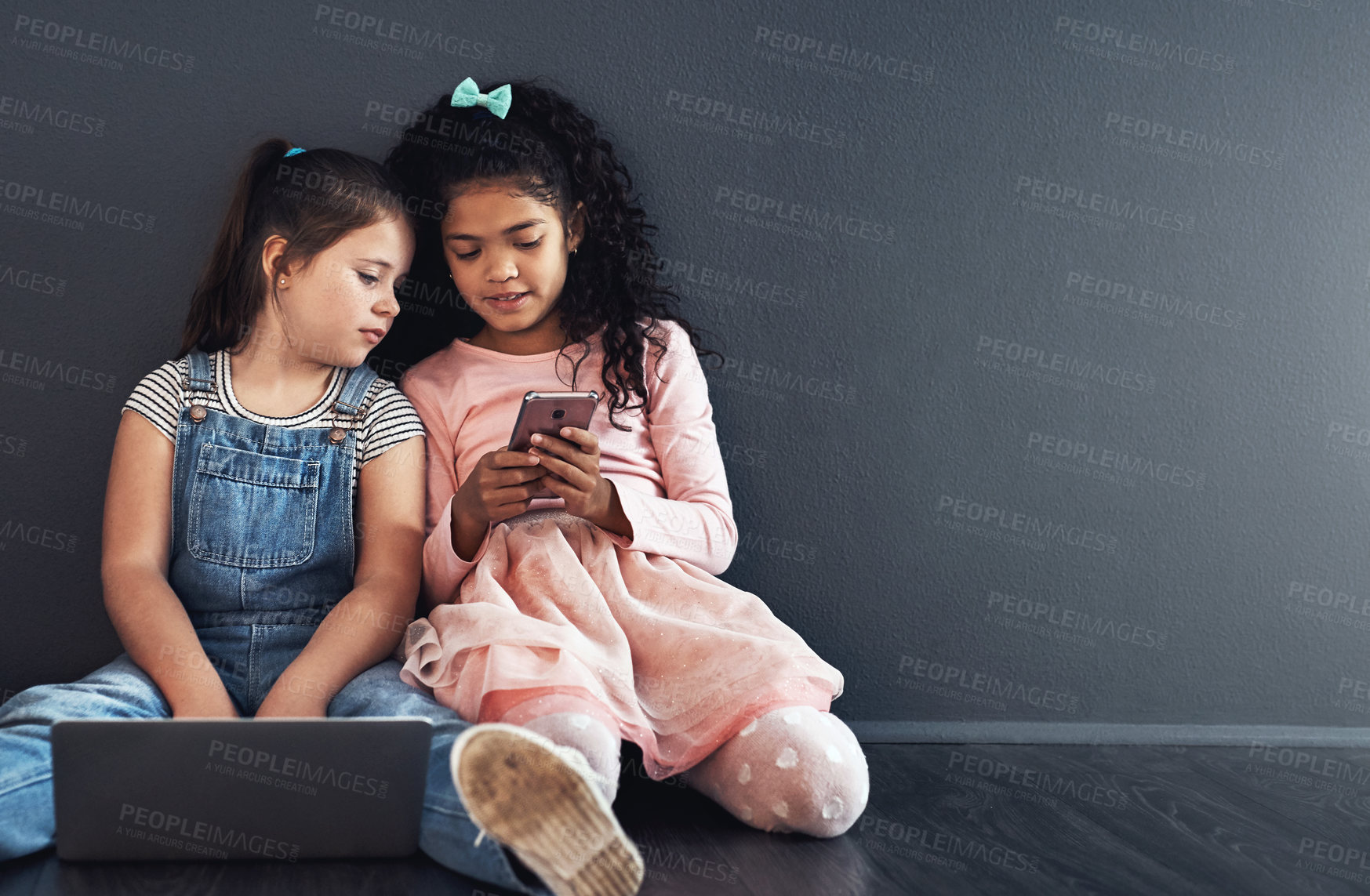 Buy stock photo Girl, children and together with phone on floor by wall, reading and mockup space with web in home. Sisters, adoption and blended family by computer, smartphone and mobile app for games in apartment