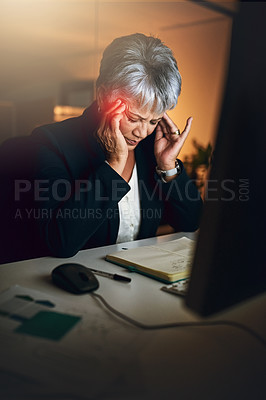 Buy stock photo Shot of a mature businesswoman experiencing a headache during a late night at work