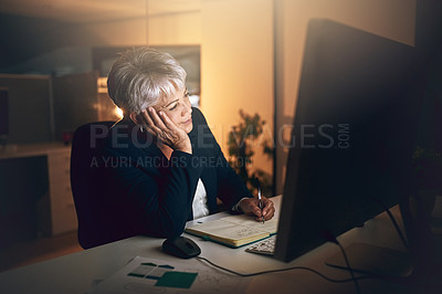 Buy stock photo Shot of a mature businesswoman feeling bored during a late night at work
