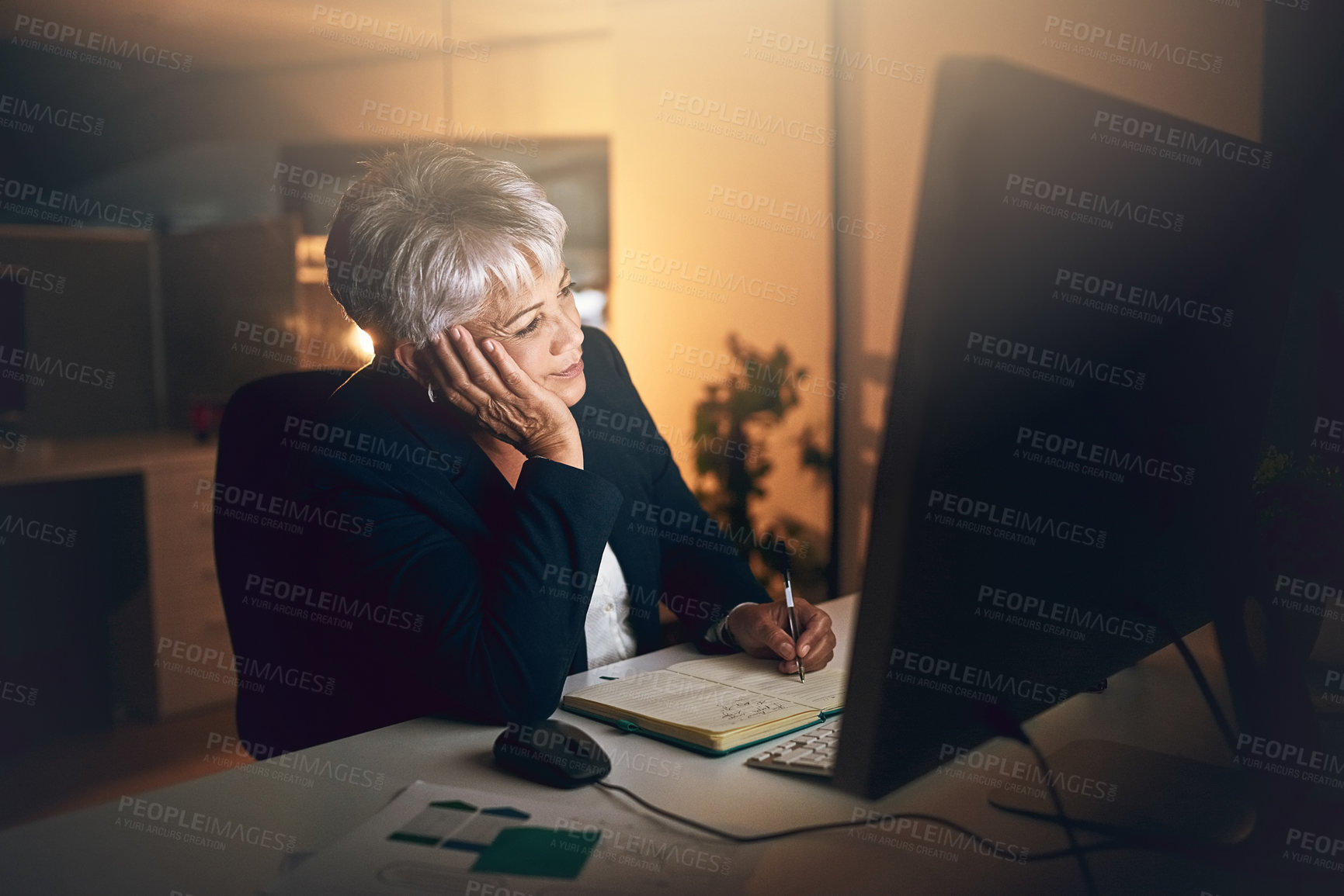 Buy stock photo Shot of a mature businesswoman feeling bored during a late night at work