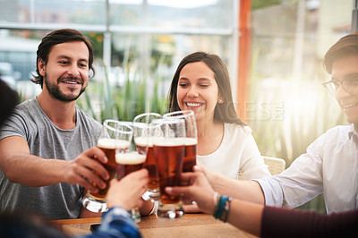 Buy stock photo Shot of a group of young business colleagues having a celebratory toast with beer around a table outside