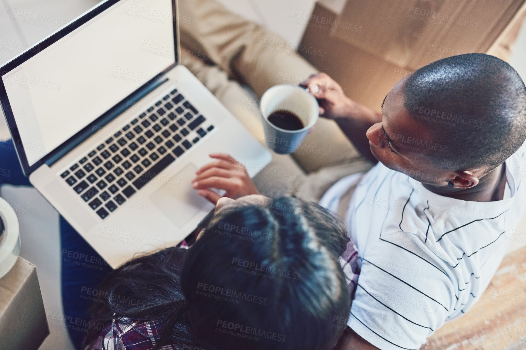 Buy stock photo High angle shot of a young couple using a laptop while moving house