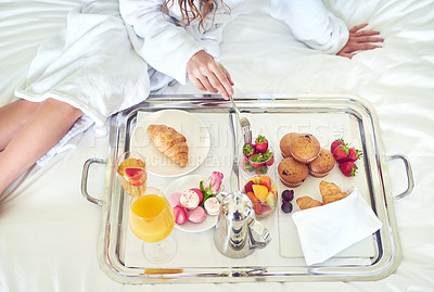 Buy stock photo High angle shot of an unrecognizable woman enjoying a healthy breakfast on her hotel bed