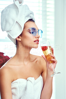 Buy stock photo Shot of an attractive young woman enjoying a glass of champagne while going through her morning routine