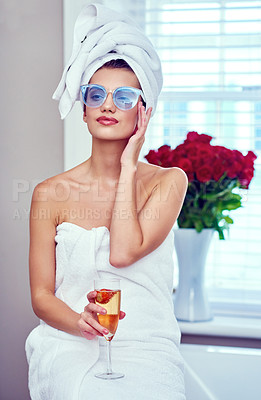Buy stock photo Shot of an attractive young woman enjoying a glass of champagne while going through her morning routine