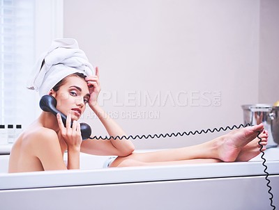 Buy stock photo Portrait of an attractive young woman talking on a telephone while sitting in a bathtub