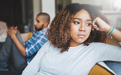 Buy stock photo Unhappy, angry and stressed couple sitting on a sofa together after arguing. Young african american man and woman looking annoyed and ready for divorce while experiencing relationship problems