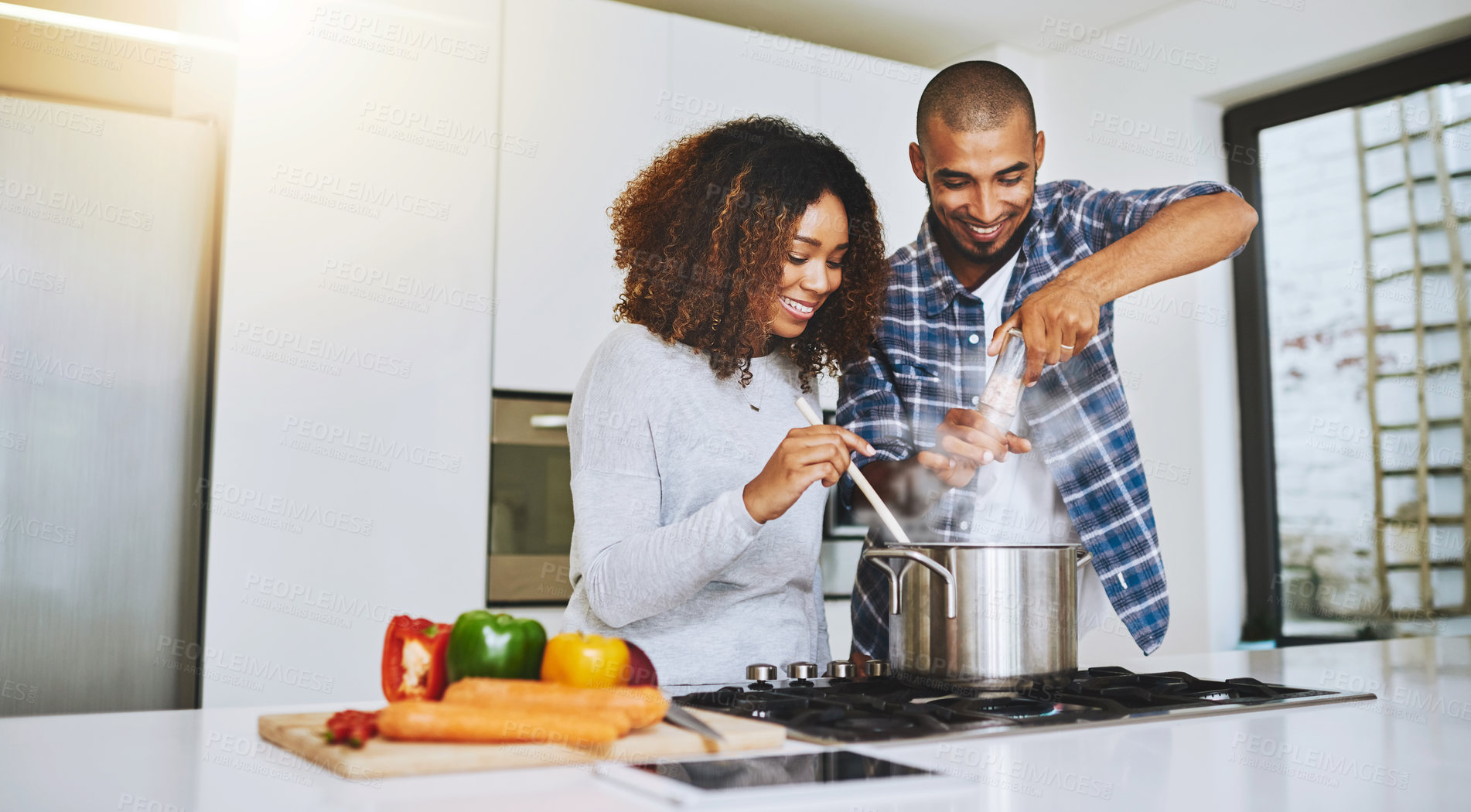 Buy stock photo Shot of a young couple cooking together at home