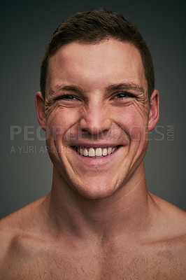 Buy stock photo Studio closeup of a cheerful young man standing against a grey background while looking into the background