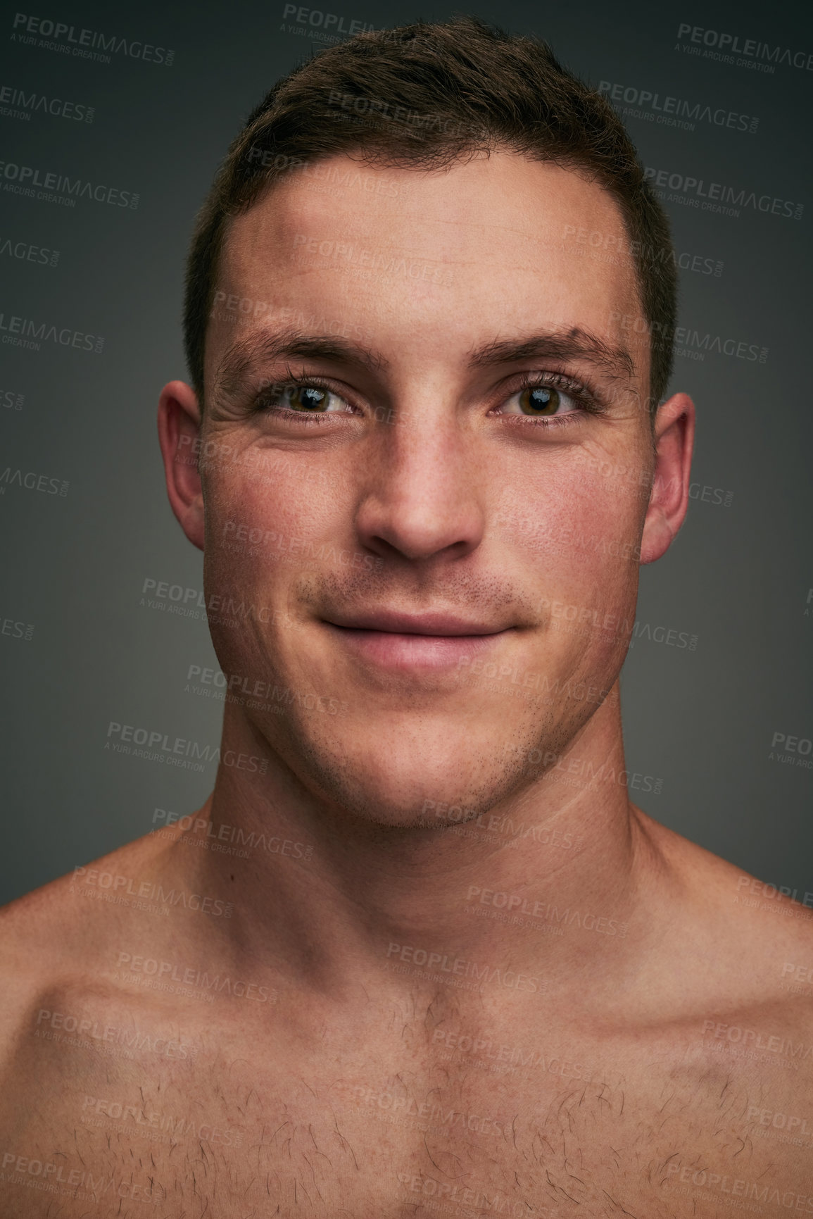 Buy stock photo Studio closeup of a cheerful young man standing against a grey background while looking into the background