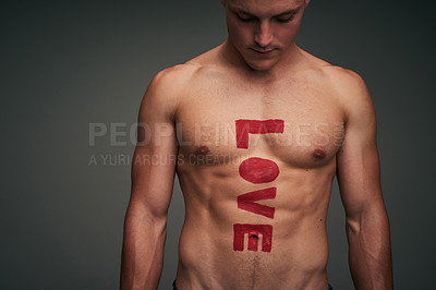 Buy stock photo Studio shot of a shirtless young man against a gray background with the word 