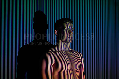 Buy stock photo Studio shot of a young man posing against abstract lighting