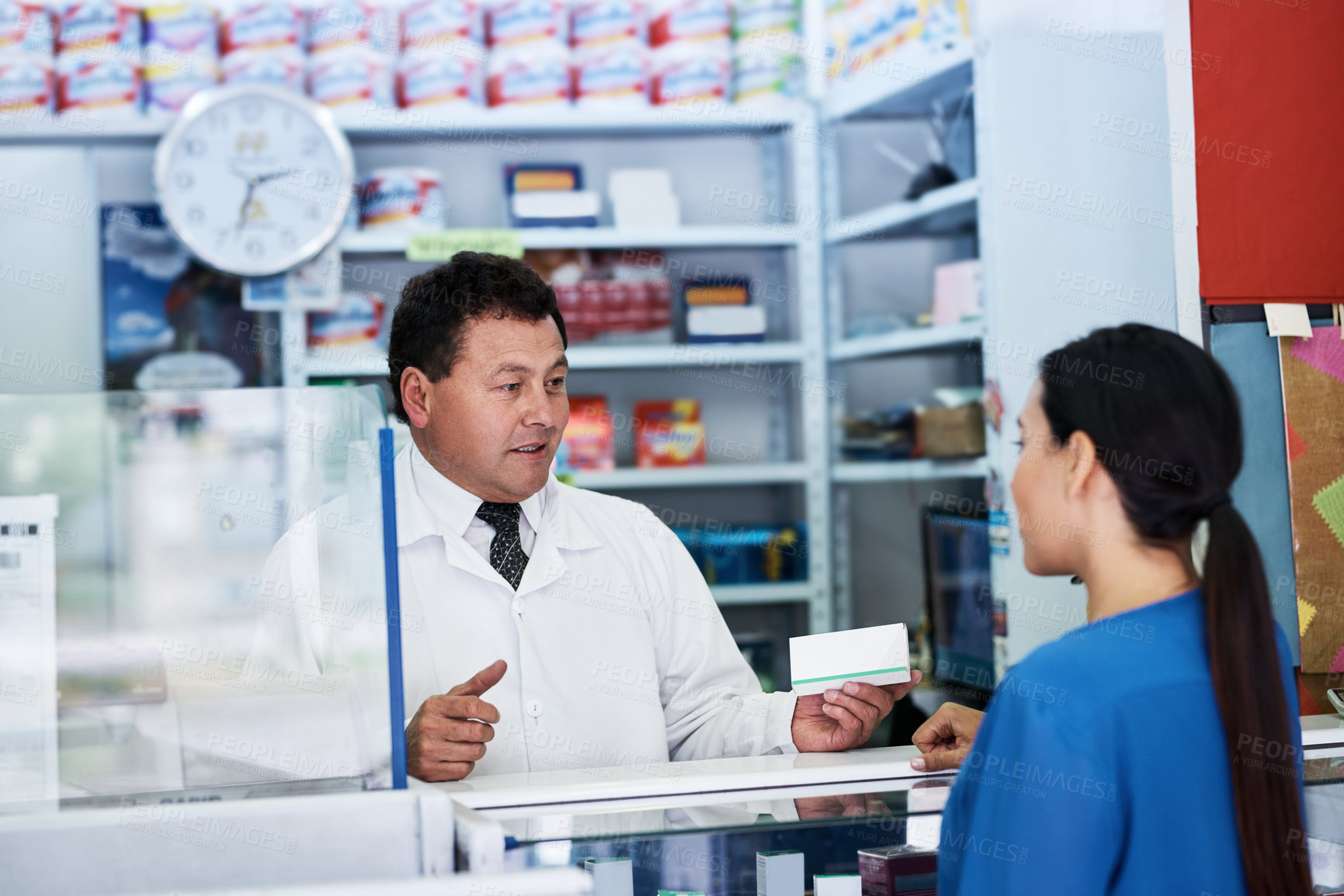 Buy stock photo Shot of a male pharmacist helping a female customer in a pharmacy