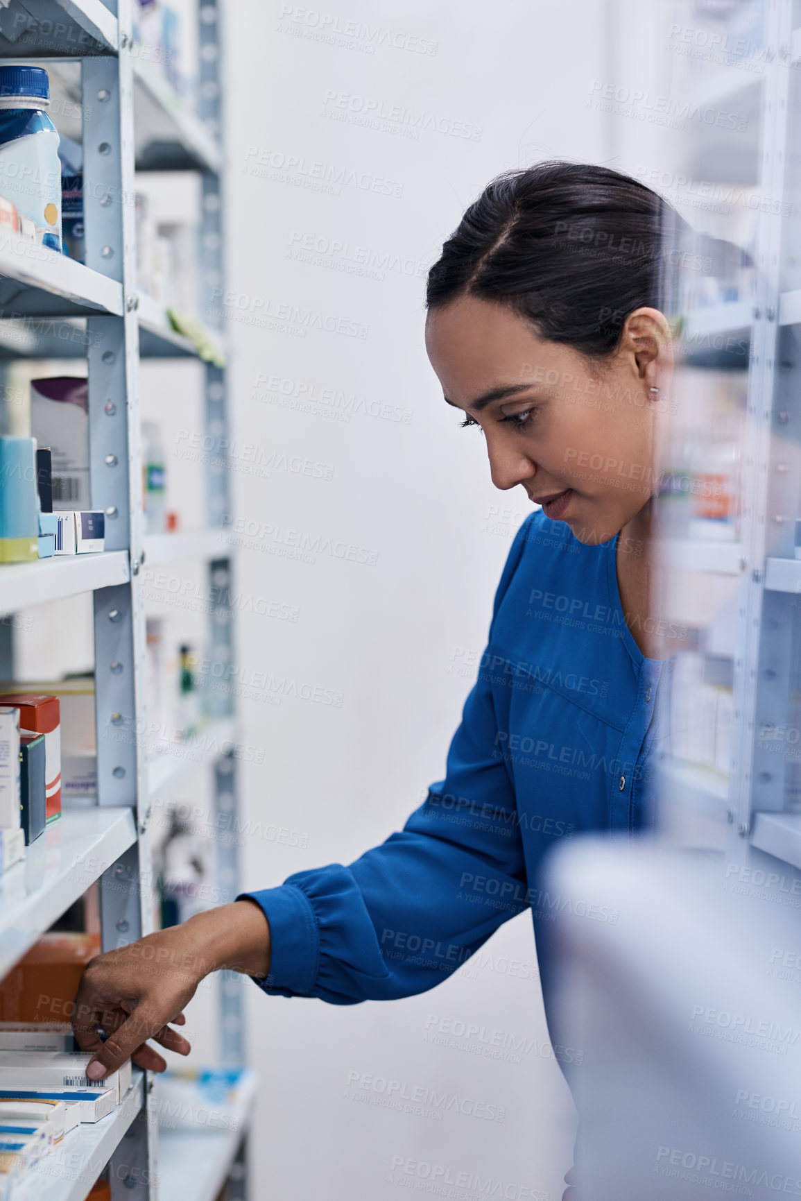 Buy stock photo Shot of a young woman shopping at a pharmacy