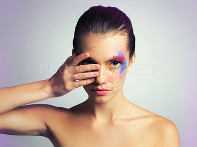 Buy stock photo Studio shot of an attractive young woman posing with her face brightly painted